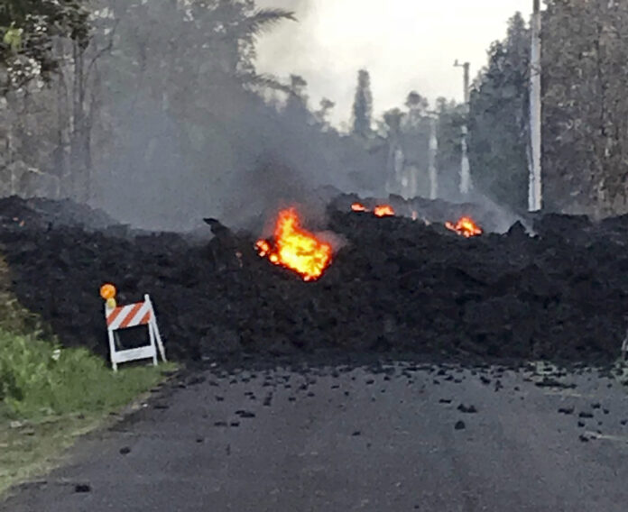 The image on Friday shows lava flowing over Mohala Street in the Leilani Estates area near Pahoa on the Big Island of Hawaii. Photo: Hawaii Electric Light / Associated Press