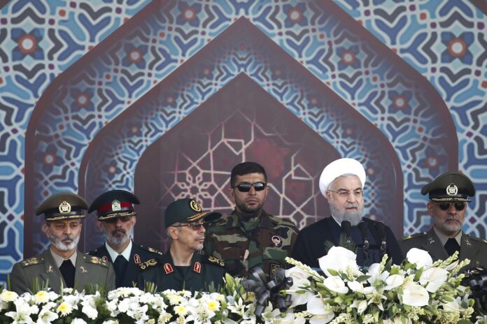 Iranian President Hassan Rouhani, second right, speaks at a military parade marking the 37th anniversary of Iraq's 1980 invasion of Iran,in 2017 just outside Tehran, Iran. Photo: Ebrahim Noroozi / Associated Press