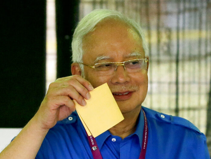 Malaysian Prime Minister Najib Razak shows his ballot as he votes May 9 at his hometown in Pekan, Pahang state, Malaysia. Photo: Aaron Favila / Associated Press