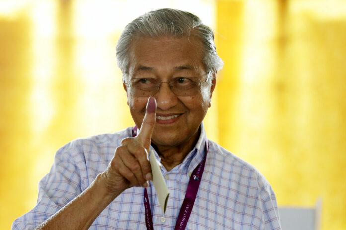 Former Malaysian strongman Mahathir Mohamad shows his finger that is marked in ink after voting in May for the general election in Alor Setar, state capital of Kedah, northern Malaysia. Photo: Andy Wong / Associated Press