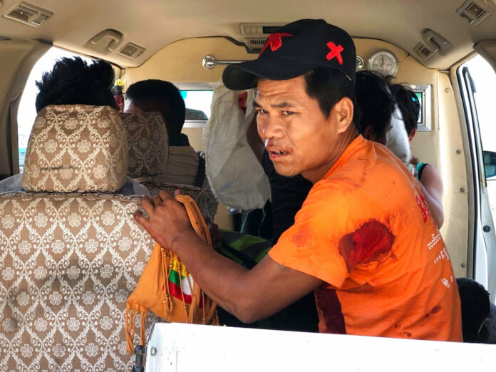 An injured man sits inside a vehicle Saturday in Muse, northern Shan state, Myanmar. Photo: Thaung Tu / Associated Press