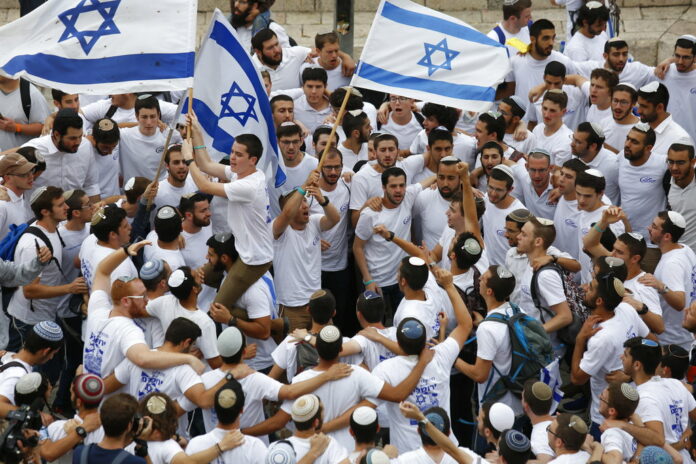 Israeli youths wave national flags in May outside the Old City's Damascus Gate, in Jerusalem. Photo: Ariel Schalit / Associated Press