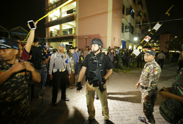 Indonesian police stand guards in front of a flat Sunday after an explosion in Sidoarjo, East Java, Sunday. Photo: Achmad Ibrahim / Associated Press