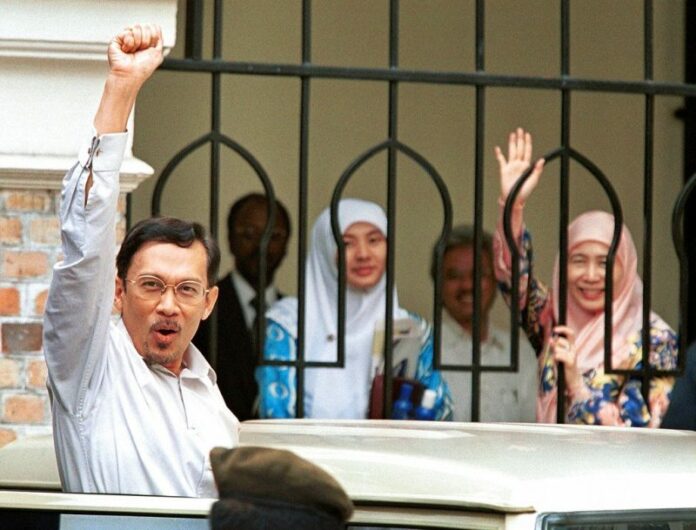 Malaysian ousted Deputy Prime Minister Anwar Ibrahim raises his fist as he leaves the Federal High Court on Thursday in Kuala Lumpur. Photo: Andy Wong / Associated Press