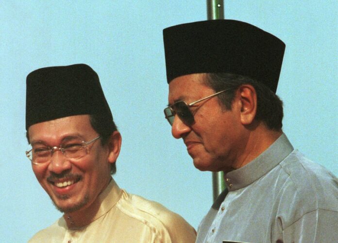 Anwar Ibrahim, left, stands next to Malaysia Prima Minister Mahathir Mohamad during the 1998 UMNO Annual Meeting in Kuala Lumpur. Photo: Vincent Thian / Associated Press