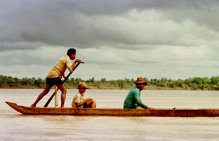 Villagers ride a dugout up the Mekong River in 1996 near Sambor, Cambodia where a major dam has been proposed. Photo: Richard Vogel / Associated Press