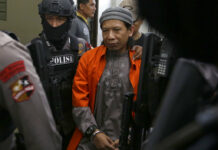 Indonesia Seeks Death for Cleric Accused of Ordering Attacks Islamic cleric Aman Abdurrahman, center, is escorted by police officers upon arrival for his trial at South Jakarta District Court on Friday in Jakarta, Indonesia. Photo: Tatan Syuflana / Associated Press