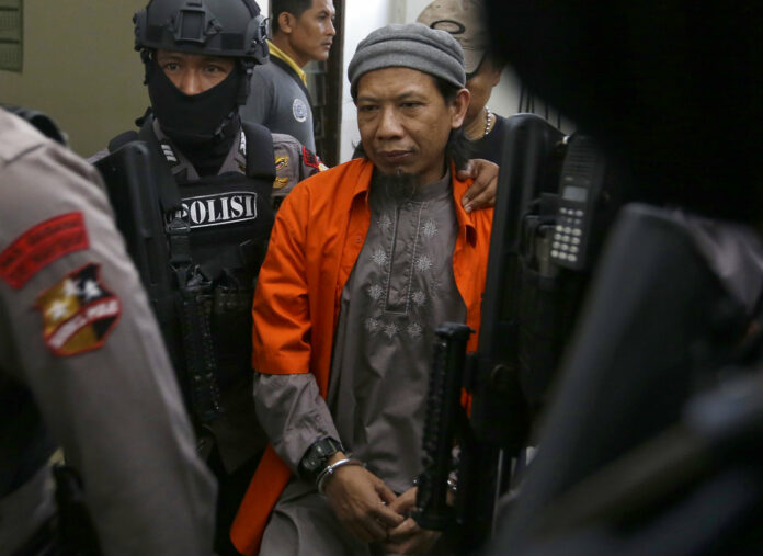 Islamic cleric Aman Abdurrahman, center, is escorted by police officers upon arrival for his trial at South Jakarta District Court on Friday in Jakarta, Indonesia. Photo: Tatan Syuflana / Associated Press Islamic cleric Aman Abdurrahman, center, is escorted by police officers upon arrival for his trial at South Jakarta District Court on Friday in Jakarta, Indonesia. Photo: Tatan Syuflana / Associated Press