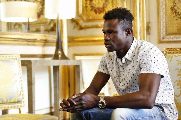 Mamoudou Gassama, 22, from Mali, is pictured during a meeting with French President Emmanuel Macron at the presidential Elysee Palace in Paris, Monday, May, 28, 2018. Photo: Thibault Camus, Pool