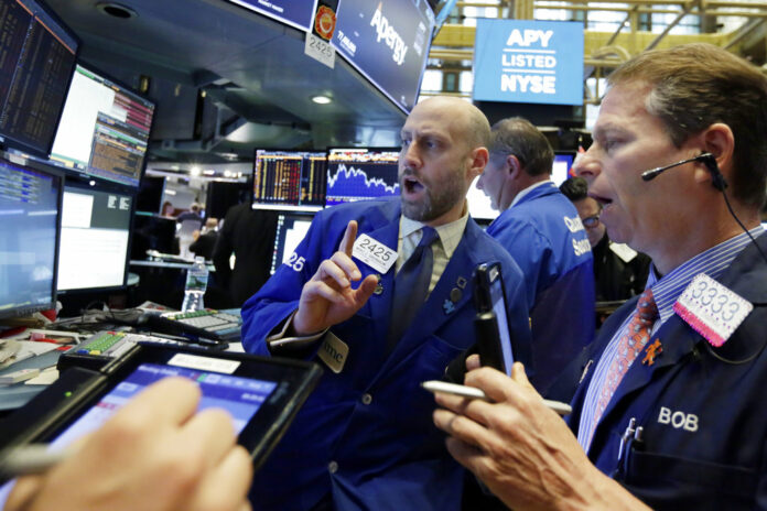 Specialist Meric Greenbaum, center, works with traders at his post in May on the floor of the New York Stock Exchange. Photo: Richard Drew / Associated Press