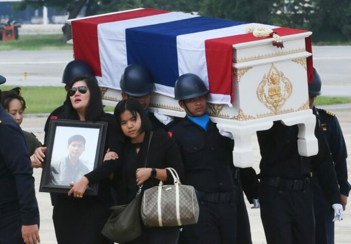 Air Marshal Kroekkiat Suwanno’s family carries his body Wednesday at the Wing 6 air base in Tak.
