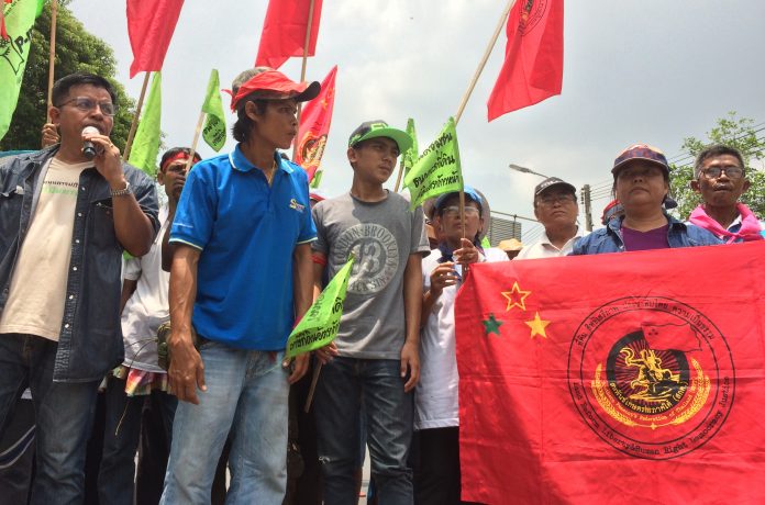 Chamnong Nupan of P-Move network, at left, speaks to reporters at their protest site Thursday
