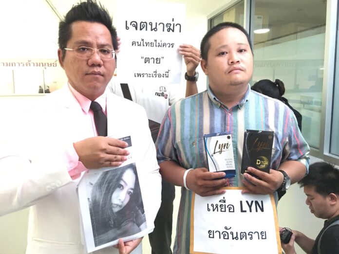 Wuttikorn Mhon-ing, right, files a complaint Thusday to the Consumer Protection Police after his older sister Pimlawan Mhon-ing, 31, died March 28 due to ingesting Lyn diet pills. “Killing with intent. Thais should not die because of this” and “Victim of Lyn, dangerous medicine,” reads the signs.