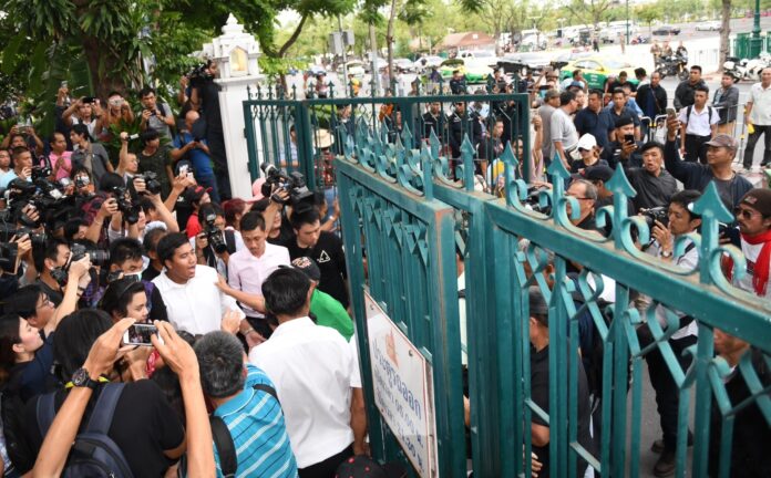 Protest leaders Monday force Thammasat University’s gate open to supporters.