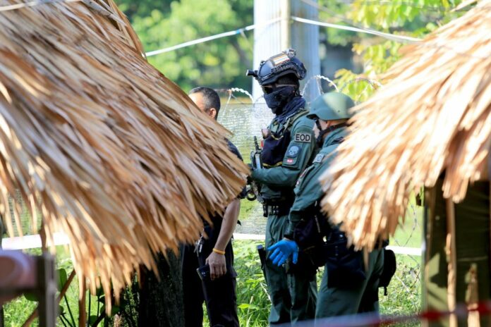 Police and soldiers inspect the site of the grenade attacks in Yala province on Tuesday