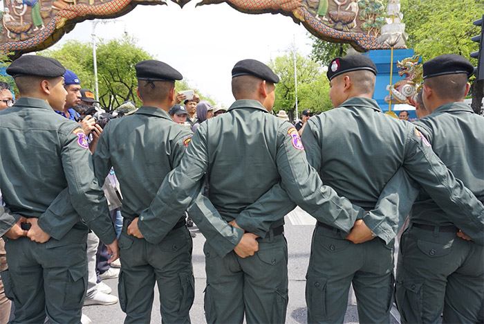 Border patrol officers lock arms before the approaching protesters Tuesday.