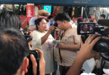 Police Summon Activists Over ‘Noodle Protest’ A woman feeds Thammasat student activist Parit “Penguin” Chiwarak with instant noodle on a BTS skywalk Monday. Image: Nuttaa Mahattana / Facebook