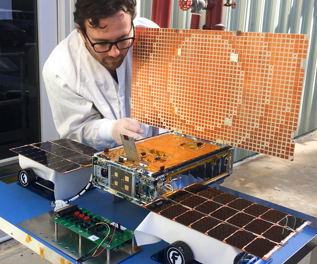 Engineer Joel Steinkraus uses sunlight to test the solar arrays on one of the Mars Cube One (MarCO) spacecraft at NASA's Jet Propulsion Laboratory in Pasadena, California. Photo: NASA / JPL