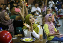 Mahathir Sworn in After Ruling Party Booted People at a restaurant applaud as they watch TV showing former strongman Mahathir Mohamad sworn in as the new Malaysian Prime Minister in Kuala Lumpur, Malaysia on Thursday. Photo: Aaron Favila / Associated Press
