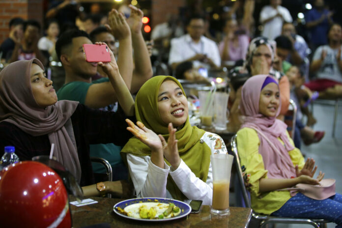 People at a restaurant applaud as they watch TV showing former strongman Mahathir Mohamad sworn in as the new Malaysian Prime Minister in Kuala Lumpur, Malaysia on Thursday. Photo: Aaron Favila / Associated Press People at a restaurant applaud as they watch TV showing former strongman Mahathir Mohamad sworn in as the new Malaysian Prime Minister in Kuala Lumpur, Malaysia on Thursday. Photo: Aaron Favila / Associated Press