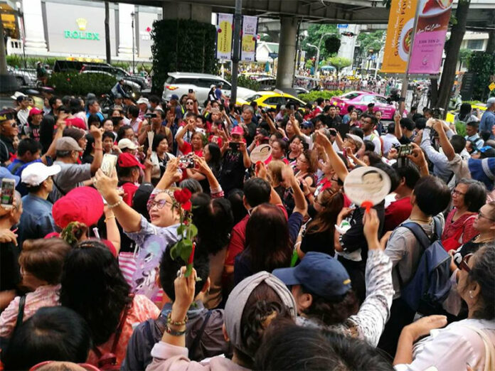 A crowd of mostly Redshirt supporters gathers Saturday evening at Ratchaprasong Intersection in Bangkok to hold a vigil for those killed in a 2010 military crackdown.