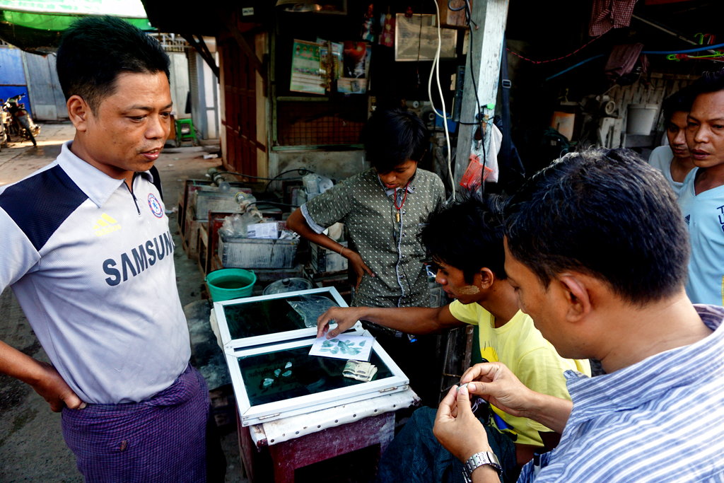 This Nov. 2, 2017, photo shows a potential customer examining some jade samples in Mandalay's famous jade market. The jade trade is dominated by the Chinese with large quantities sent to China where jade is highly valued. Photo: Denis D. Gray / Associated Press