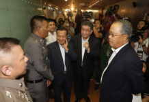 Pheu Thai Event on Junta Failures Draws Prosecution Threat Police speak to Pheu Thai Party secretary general Phumtham Wechayachai before the party held a news conference Thursday where they criticized the military regime's failures ahead of the four-year coup anniversary at party headquarters in Bangkok. Photo: Matichon