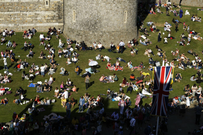 People relax on a grassy bank outside Windsor Castle after Prince Harry and Meghan Markle's wedding ceremony at St. George's Chapel in Windsor, England, on Saturday. Photo: Matt Dunham / Associated Press People relax on a grassy bank outside Windsor Castle after Prince Harry and Meghan Markle's wedding ceremony at St. George's Chapel in Windsor, England, on Saturday. Photo: Matt Dunham / Associated Press