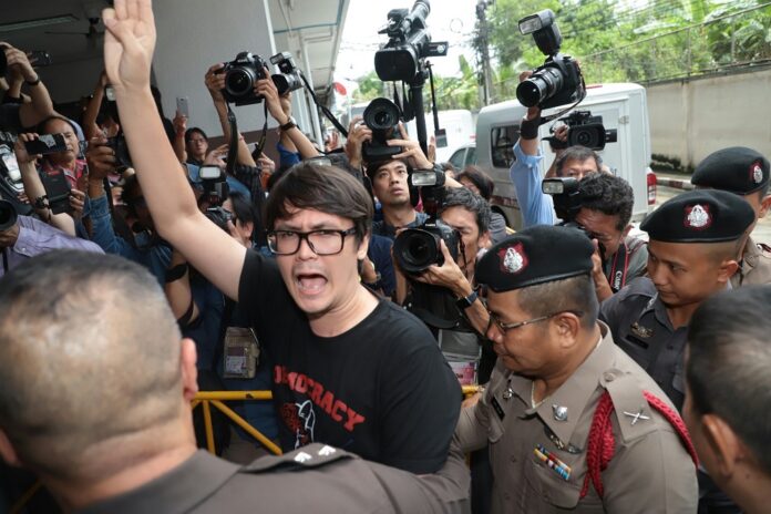 Rangsiman Rome flashes the three finger salute at the court Thursday