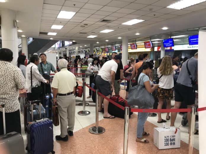 Passengers queue for a check-in at Chiang Mai International Airport. Photo: Matichon Passengers queue for a check-in at Chiang Mai International Airport. Photo: Matichon