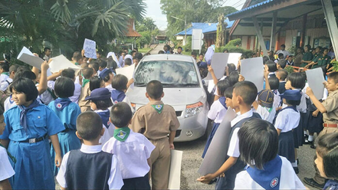 Elementary school students surround the car of detested teacher Thursday in Satun province.