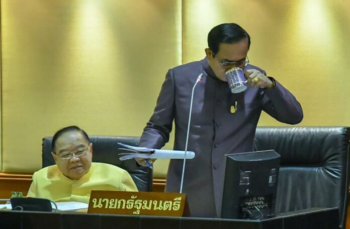 Junta chairman Prayuth Chan-ocha pauses for a sip Thursday during an hour-long speech to parliament on his 3 trillion-baht budget proposal as his deputy Prawit Wongsuwan looks on.
