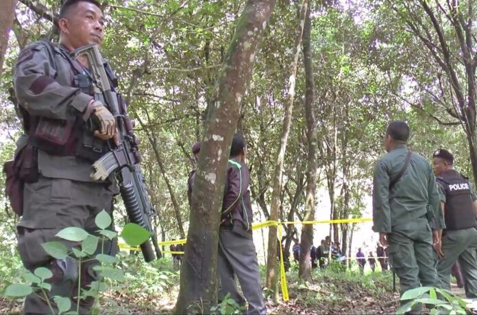 Armed soldiers stand guard at the scene of the Thursday shooting in Narathiwas province.