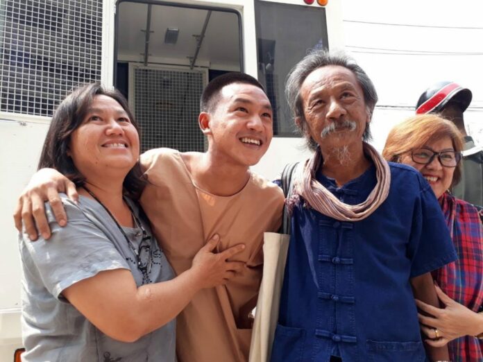 Lese majeste convict Jatupat 'Pai' Boonpattararaksa poses for a photo with his parents on March 22 after attending a court hearing on violating the junta's ban on protests.