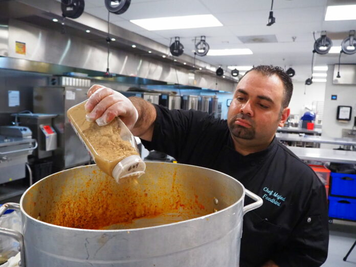 Majed Abdalraheem, 29, a Syrian refugee and chef with meal delivery service Foodhini, prepares Moussaka, a grilled eggplant dish, in May at Union Kitchen in Washington. Photo: Noreen Nasir / Associated Press