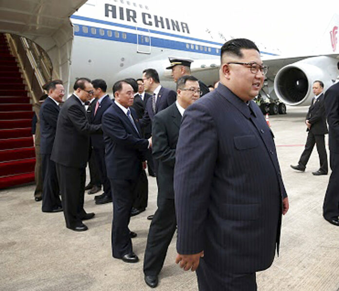 In this photo released by the Ministry of Communications and Information of Singapore, North Korean leader Kim Jong Un, right, arrives at the Changi International Airport on Sunday.