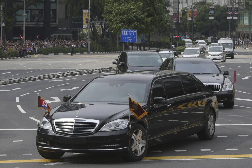 A limousine, front, with a North Korean flag believed to be carrying leader Kim Jong Un travels past Singapore's Orchard Road on its way to the St Regis Hotel on Sunday. Photo: Joseph Nair / Associated Press
