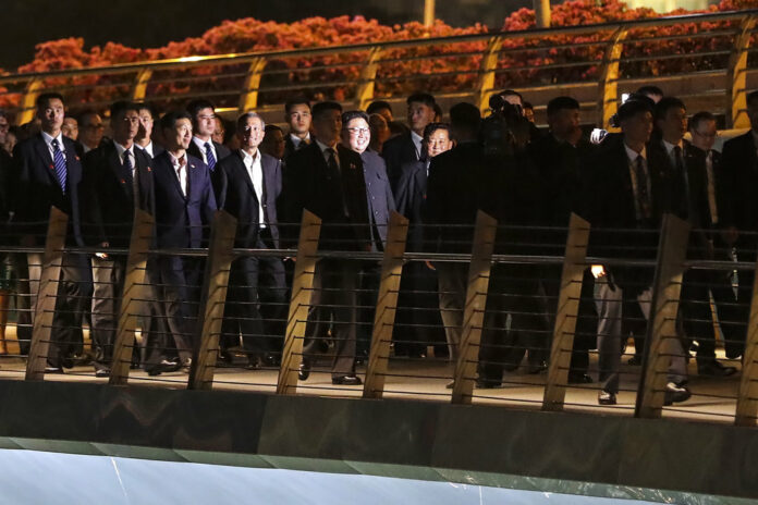 North Korean Leader Kim Jong Un is escorted by his security delegation as he visits Marina Bay in Singapore, ahead of Kim's summit with U.S. President Donald Trump. Photo : Yong Teck Lim / Associated Press