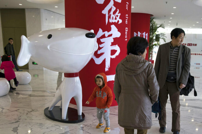 A child stands near the mascot for Chinese e-commerce giant JD.com Nov. 11, 2017 at the headquarters in Beijing, China. Photo: Ng Han Guan