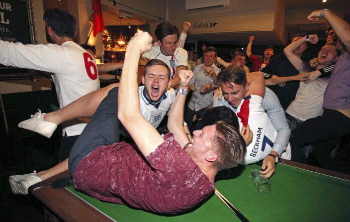 England supporters celebrate Harry Kane's winning goal as fans watch the World Cup soccer match between Tunisia and England at the Lord Raglan Pub in London, Monday, June 18, 2018. Photo: Nigel French / PA via AP