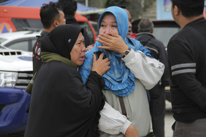 Relatives weep at Tigaras port after learning that their family members are among the passengers of a ferry which sank on Monday, in Simalungun, North Sumatera, Indonesia. Photo: Lazuardy Fahmi/ Associated Press.