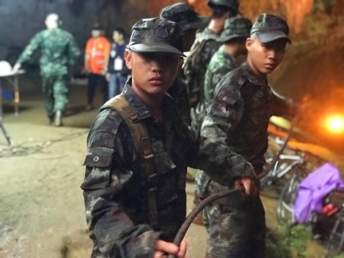 Soldiers on Tuesday guide auxiliary power lines into a cave where the main staging area is. Photo: Tassanee Vejpongsa / Associated Press