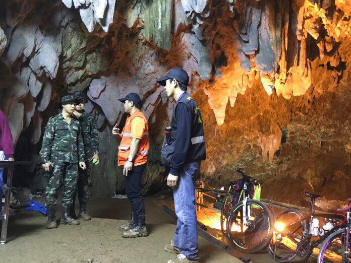 Members of the emergency rescue team talk in the staging area as they continue the search for a young football team and their coach believed to be missing in a large cave, Tuesday, June 26, 2018, in Mae Sai, Chiang Rai province. Photo: Tassanee Vejpongsa/ Associated Press