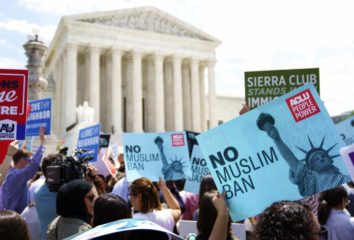 Protesters hold up signs and call out against the Supreme Court ruling upholding President Donald Trump's travel ban outside the the Supreme Court in Washington, Tuesday, June 26, 2018. Photo : Carolyn Kaster / Associated Press