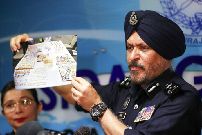 Malaysia's commercial crime investigations chief Amar Singh shows a picture of jewelry during a press conference in Kuala Lumpur, Malaysia, Wednesday, June 27, 2018. Photo: Vincent Thian/ Associated Press