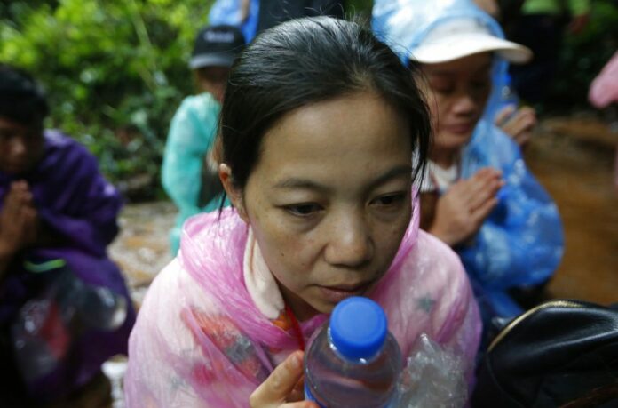 Relatives of the 12 young soccer team members and their coach on Wednesday pray for their rescue after they are believed to have gone missing in a large cave in Chiang Rai province. Photo: Sakchai Lalit / Associated Press