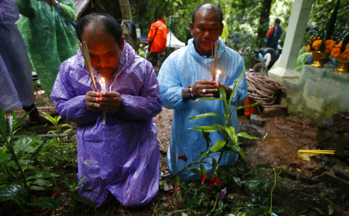 Relatives of 12 young football team members and their coach pray for their rescue after going missing in a large cave, Wednesday, June 27, 2018, in Mae Sai, Chiang Rai province. Photo: Sakchai Lalit/ Associated Press