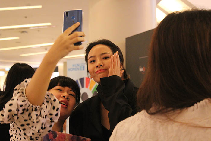 A fan takes a selfie with a model.