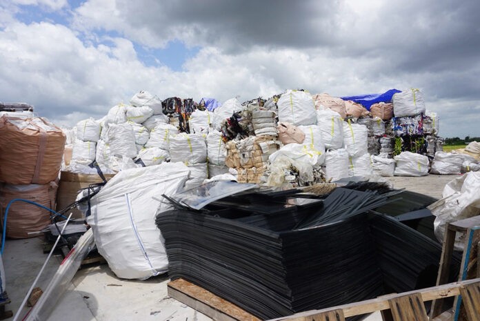 Piles of garbage tower over a Pathum Thani facility accused of illegally importing waste.