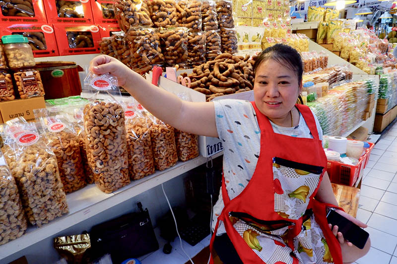 A woman sells nuts bagged in plastic.
